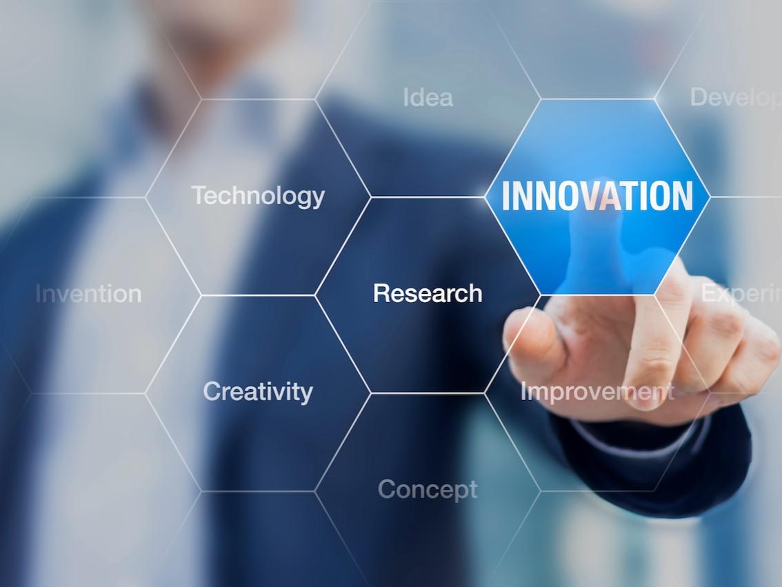 Decorative image - person at clear "white board" pointing to the word "innovation"