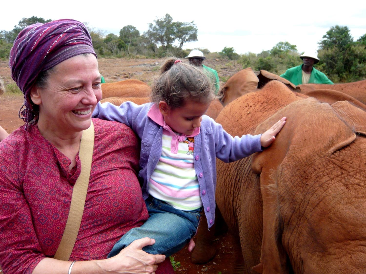 Woman and child outside with a large animal