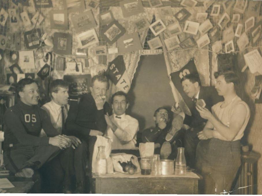 A group of students in a dorm room in the early 1900s