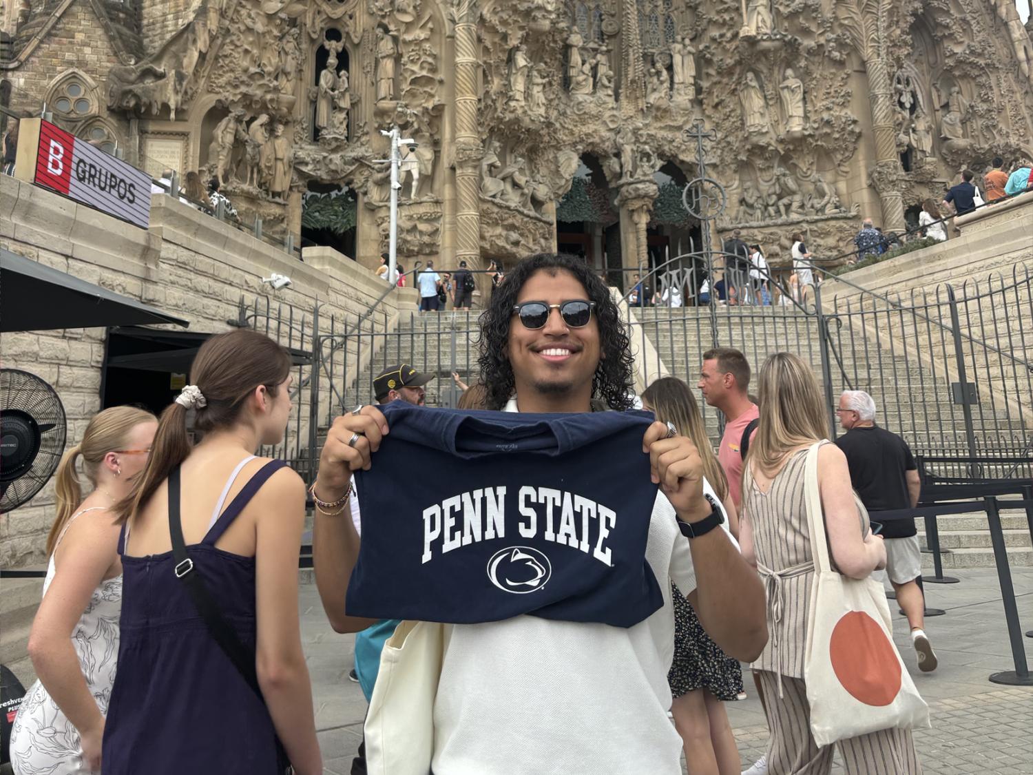 Juan Serrano holds a Penn State t-shirt in front of the Sagrada Familia in Spain