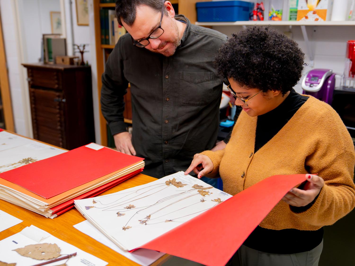Two people look at a book