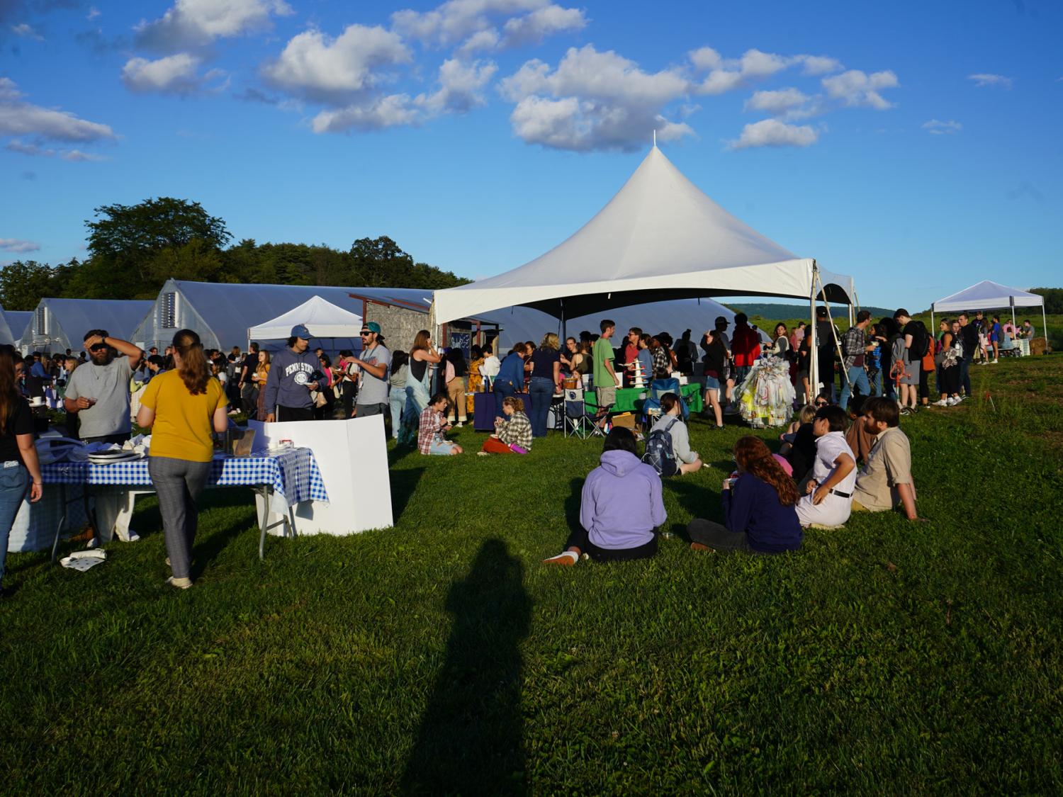 Guests gather in the grass and around displays at the Student Farm Harvest Fest