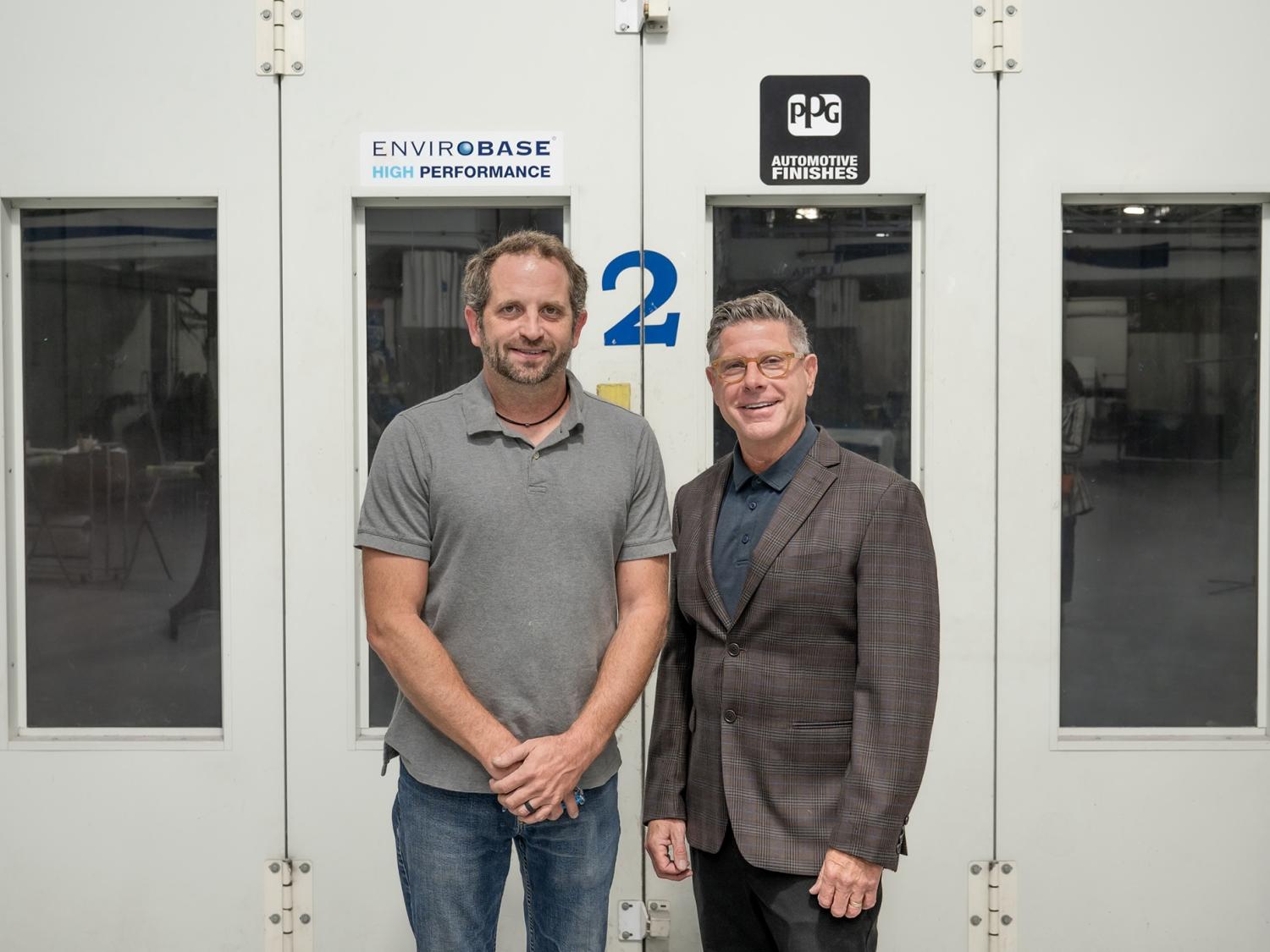 Shaun D. Hack, instructor and co-department head of collision repair at Pennsylvania College of Technology, and Todd Warren, territory manager for PPG Industries, stand in Penn College's collision repair lab