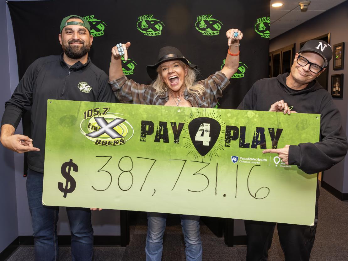 Three people smile enthusiastically as they pose with poster containing the dollar amount $387,731.16.