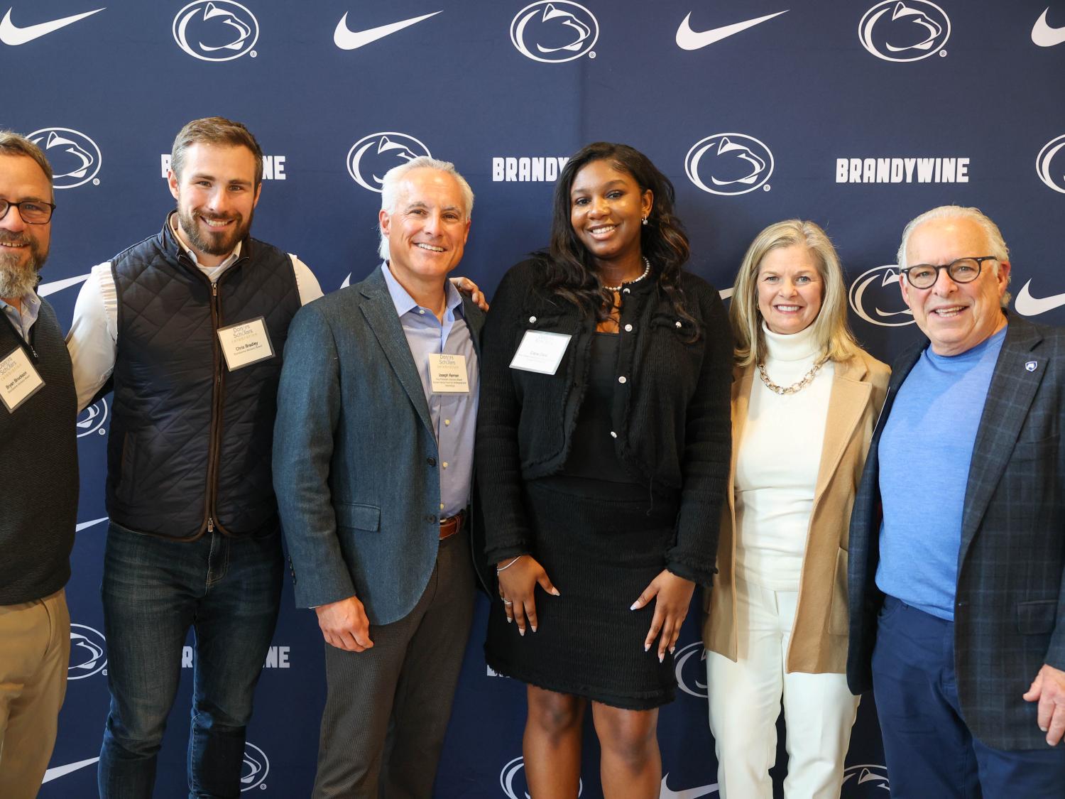 student with advisory board members pose for a photo