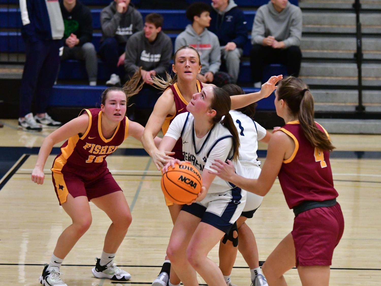 A Penn State Behrend basketball player prepares to shoot while being guarded by three opponents.