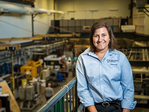 A graduate student stands on a balcony in Penn State Behrend's plastics engineering technology lab.