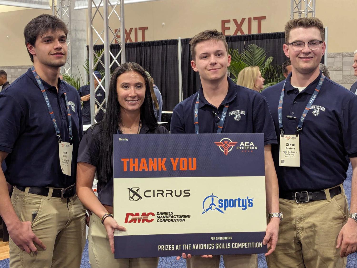 A group of four students pose for a photo.