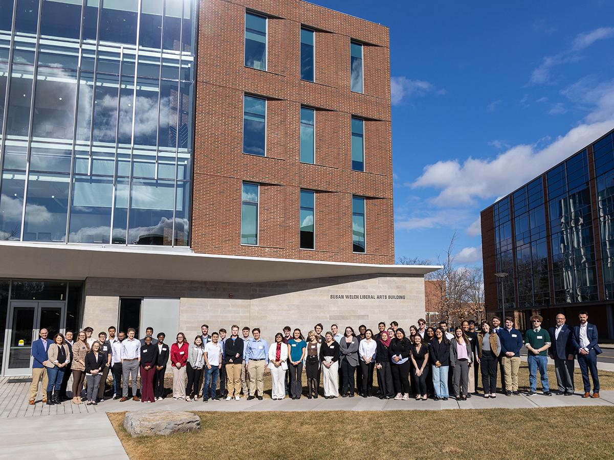 SPP simulation participants and judges pose in front of the Susan Welch Liberal Arts Building