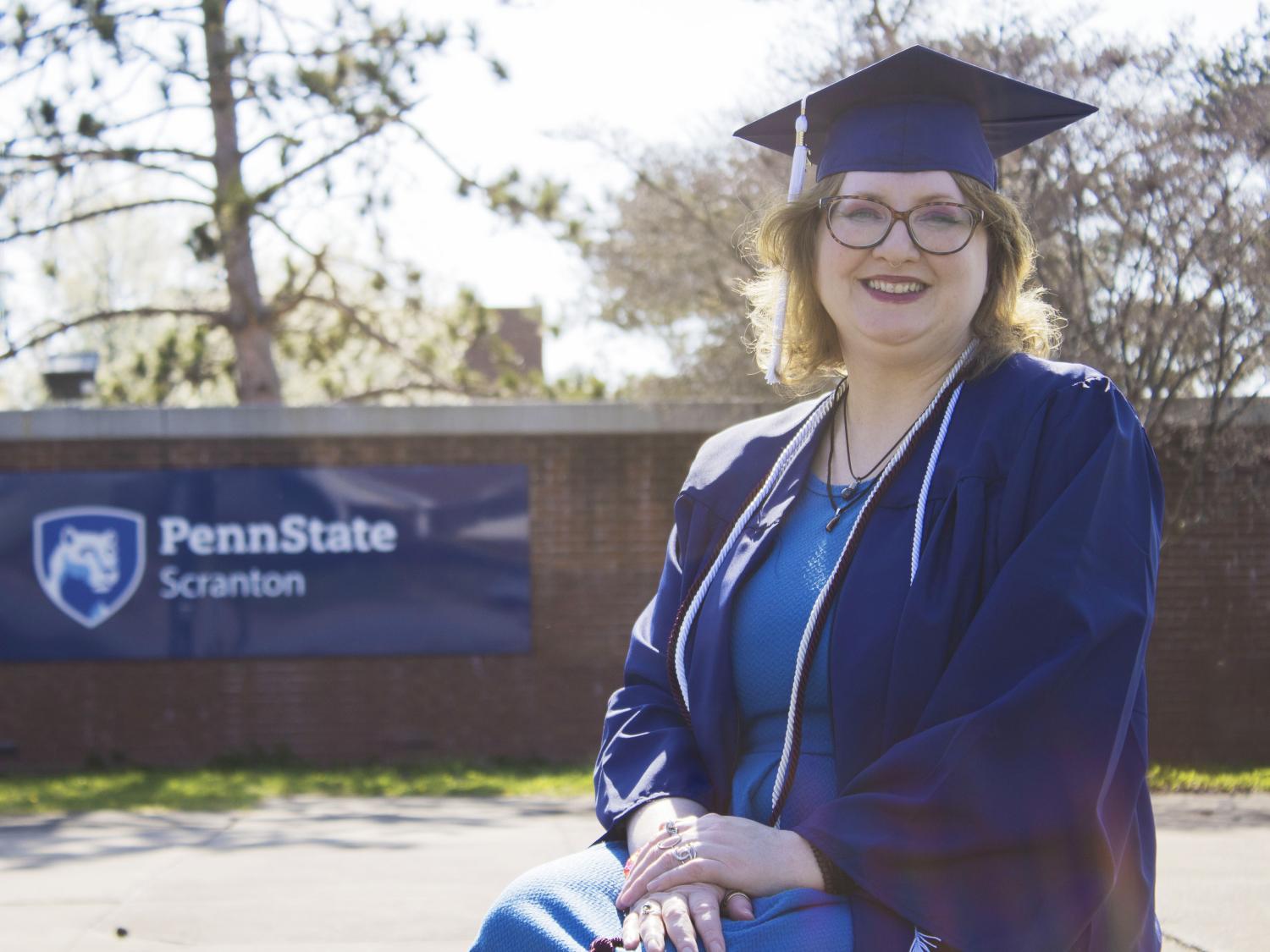 Student wearing commencement regalia and smiling
