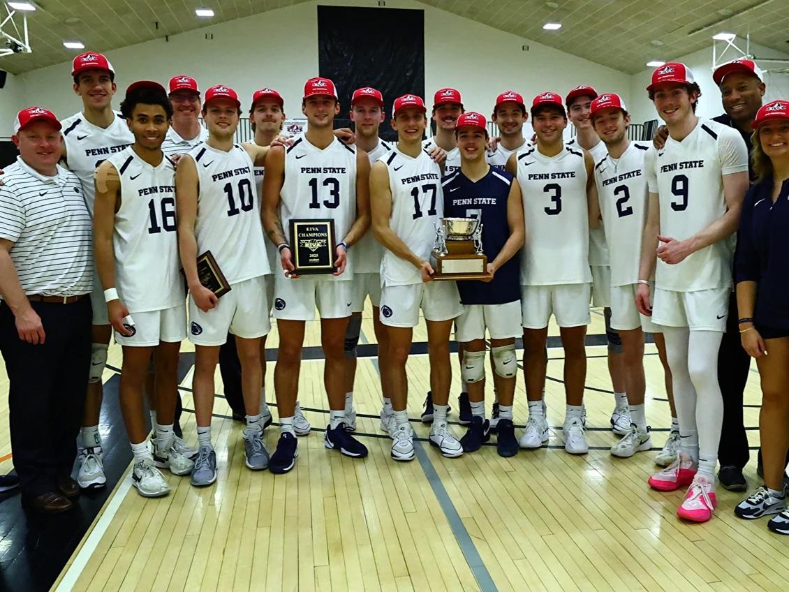 Men's volleyball team poses with trophy