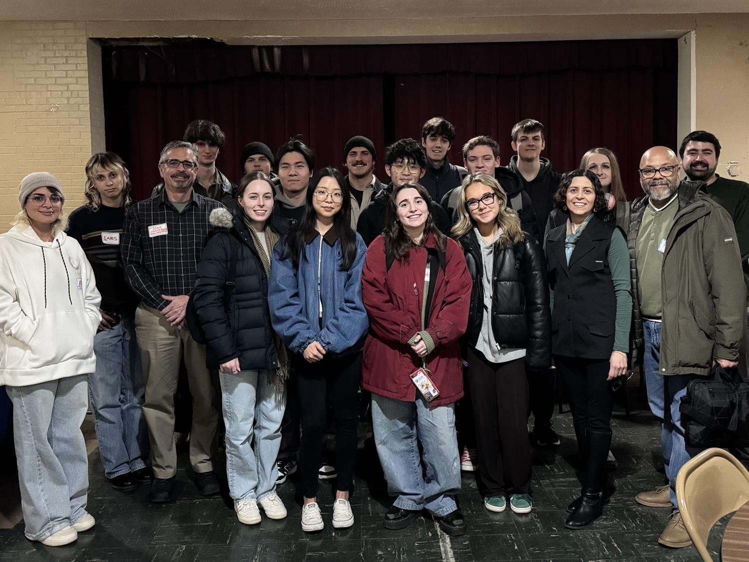 Smiling adults  in winter attire standing together posing for a photo.