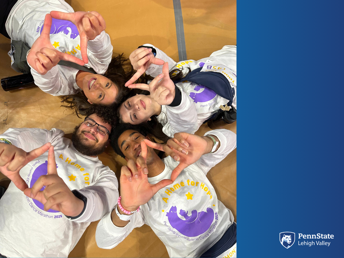 four Penn State THON dancers lay on the floor with heads touching holding up the four diamonds symbol