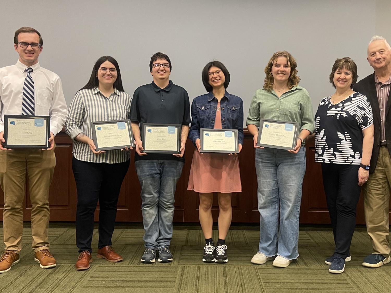 5 students holding awards standing next to John Sr. and Kimlyn Patishnock 