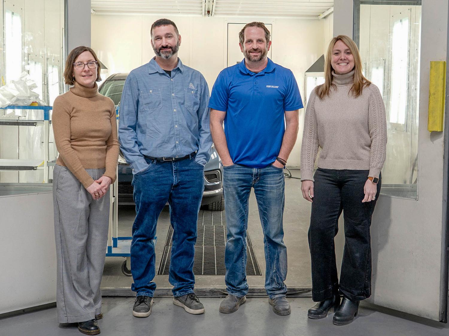 Four smiling people standing in a row.