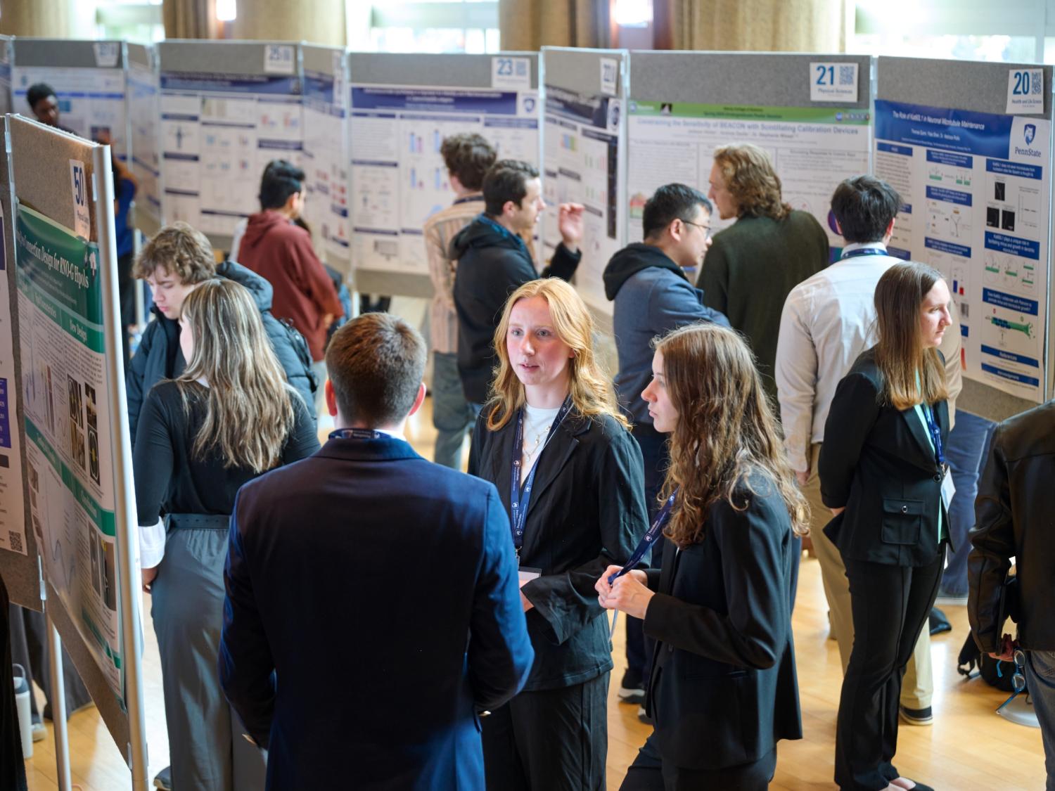 Group of students standing with research posters talking