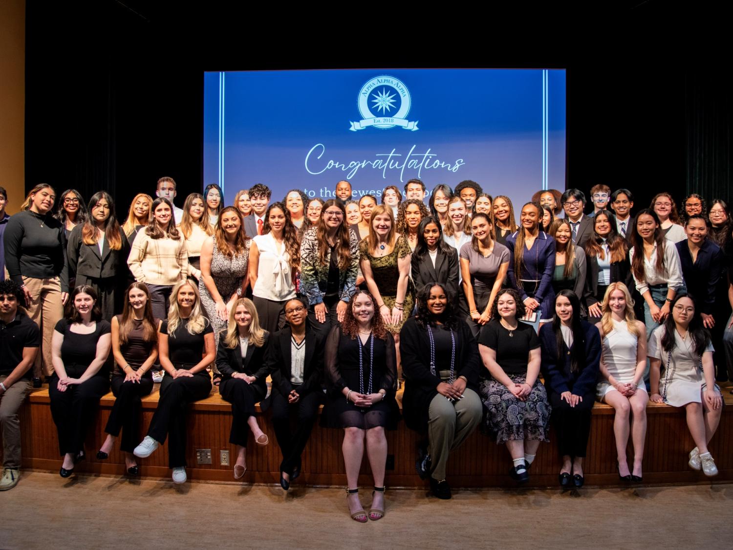 Large group of students posing for a photo on a stage