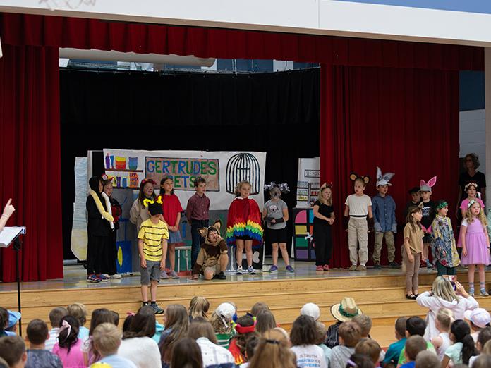 A group of elementary school students perform an opera scene at an school assembly
