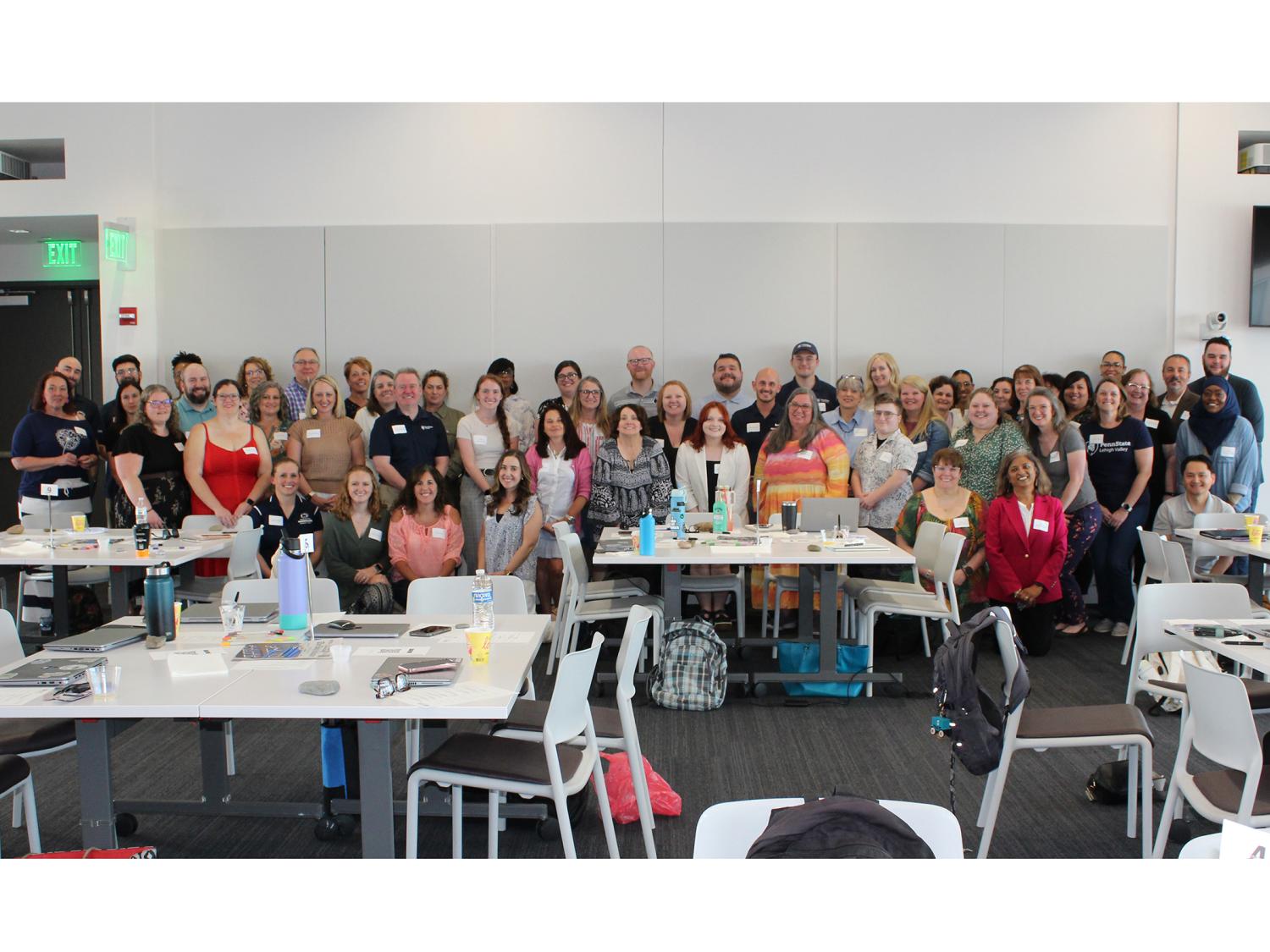 a large group of people pose together for a photo in a conference room