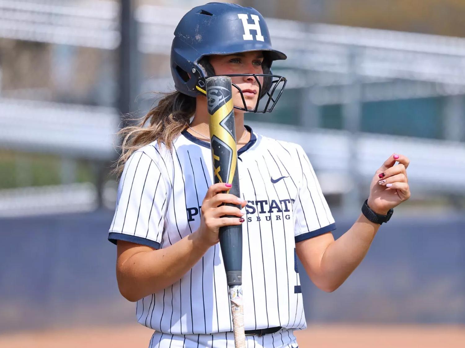 Madelyn Lehigh in a softball uniform holding a bat