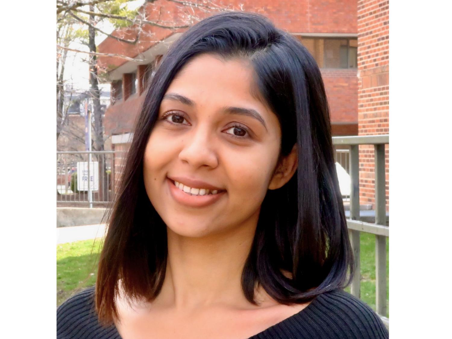 headshot of smiling person with shoulder-length dark hair