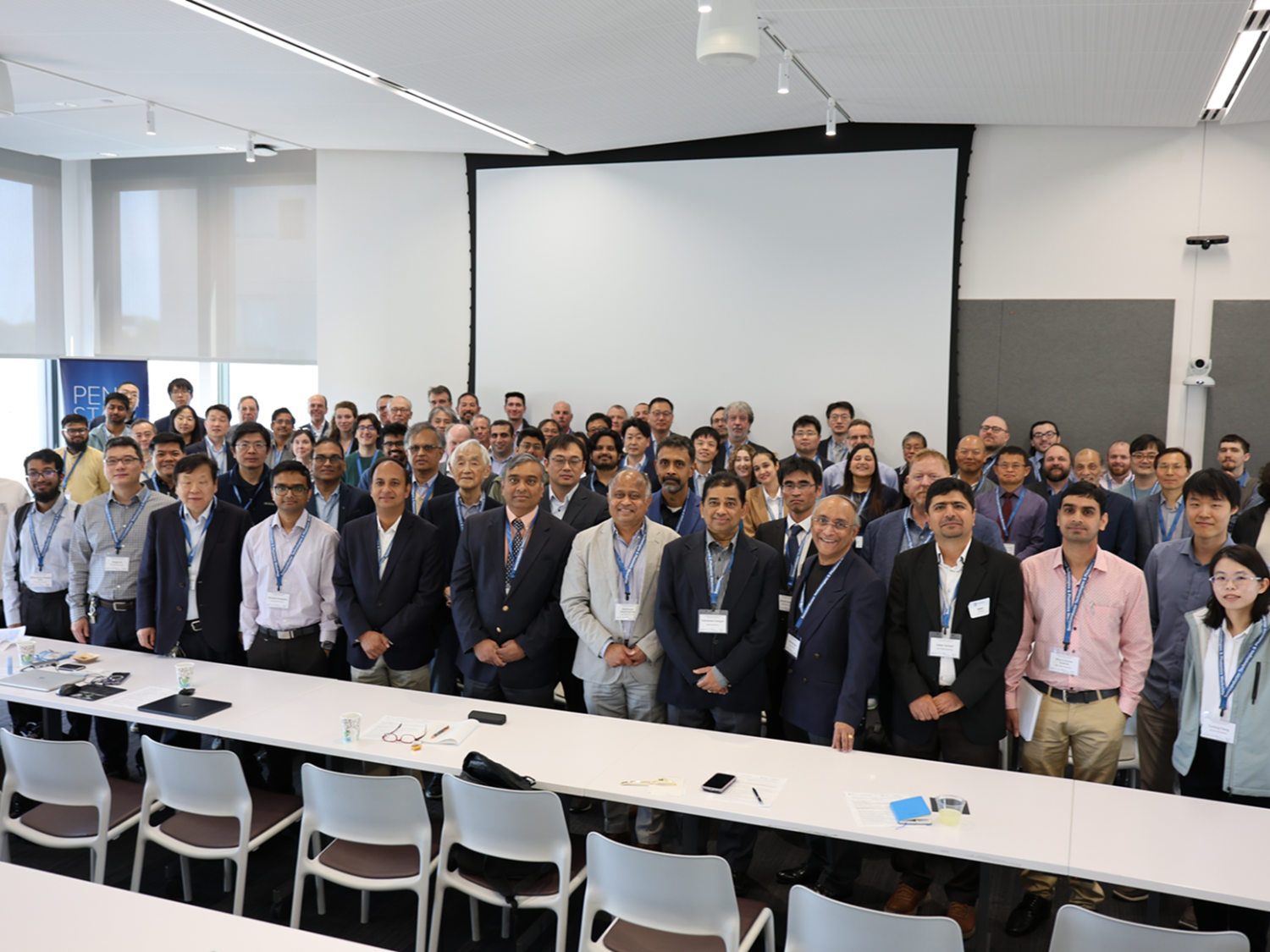 A group of people stand in a large conference room.
