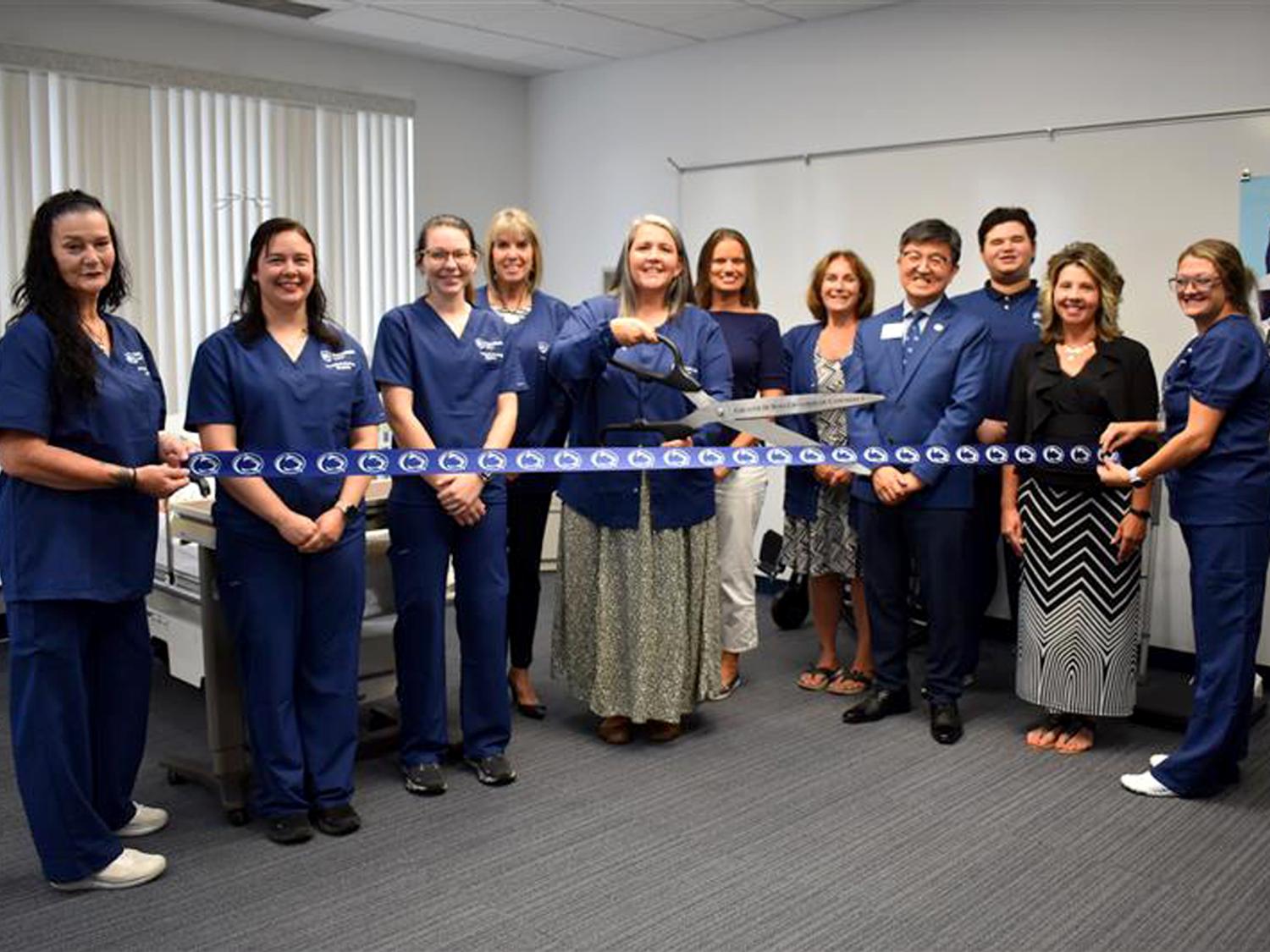 Nicki Dufour, PN Program Coordinator, prepares to cut the ribbon during the ribbon cutting ceremony for the Practical Nursing program at Penn State DuBois. Dufour was joined by students and instructors in the program, as well as other campus and community members.