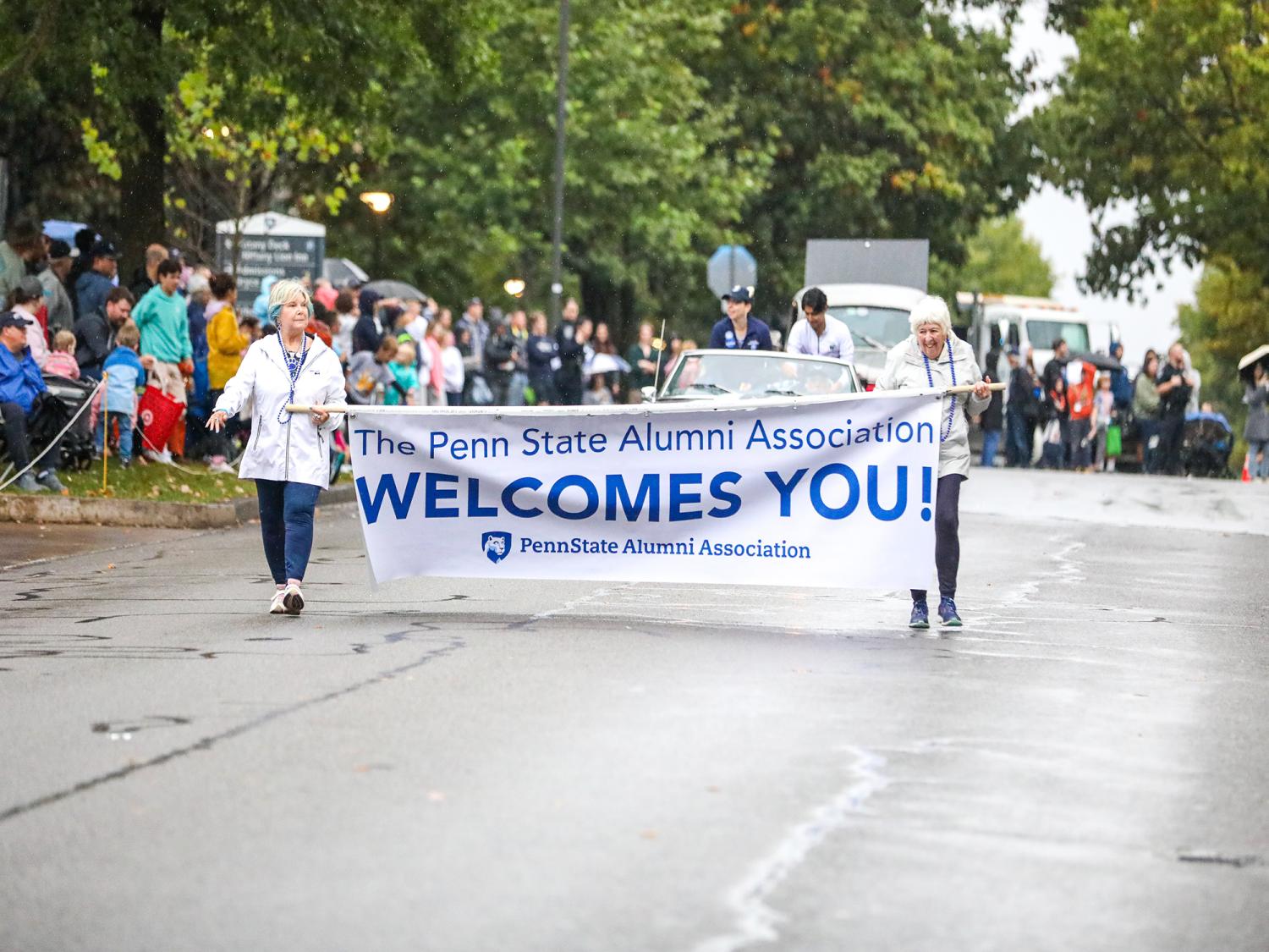 Penn State alumni carrying Homecoming banner during parade