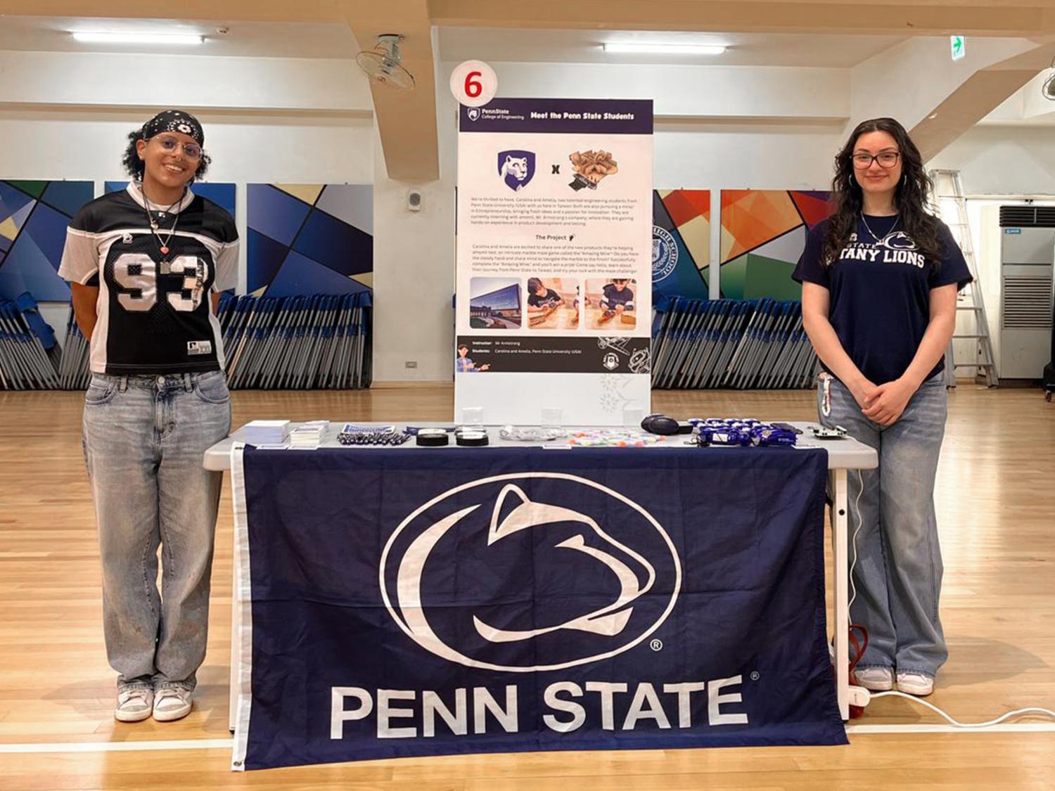 Students standing at high school fair showcasing their internship with Amoii through Penn State