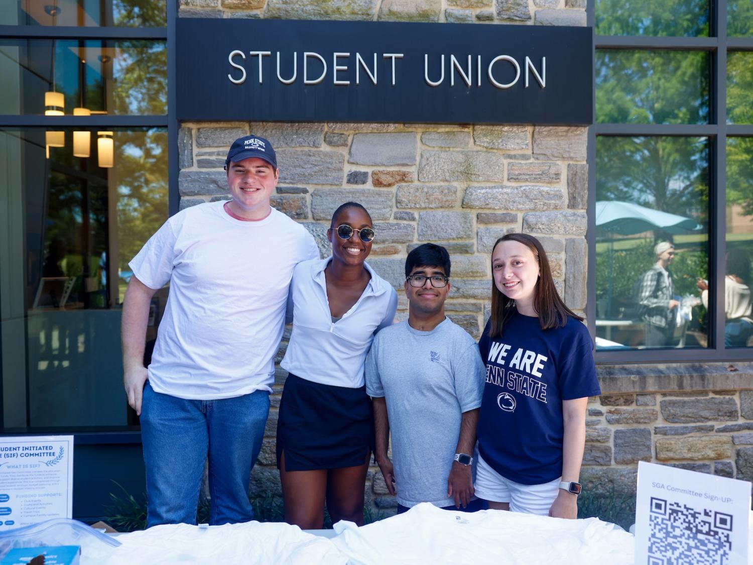 Tim McClure, Maddie Ferguson, Tejas Chigurupati and Sara Hallahan posing for a photo in front of the Student Union at an event during Week of Welcome