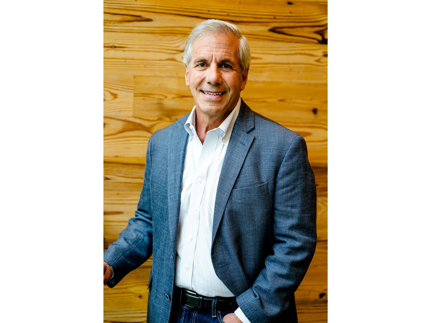 headshot of Arthur P. Pasquarella with a wood panel background