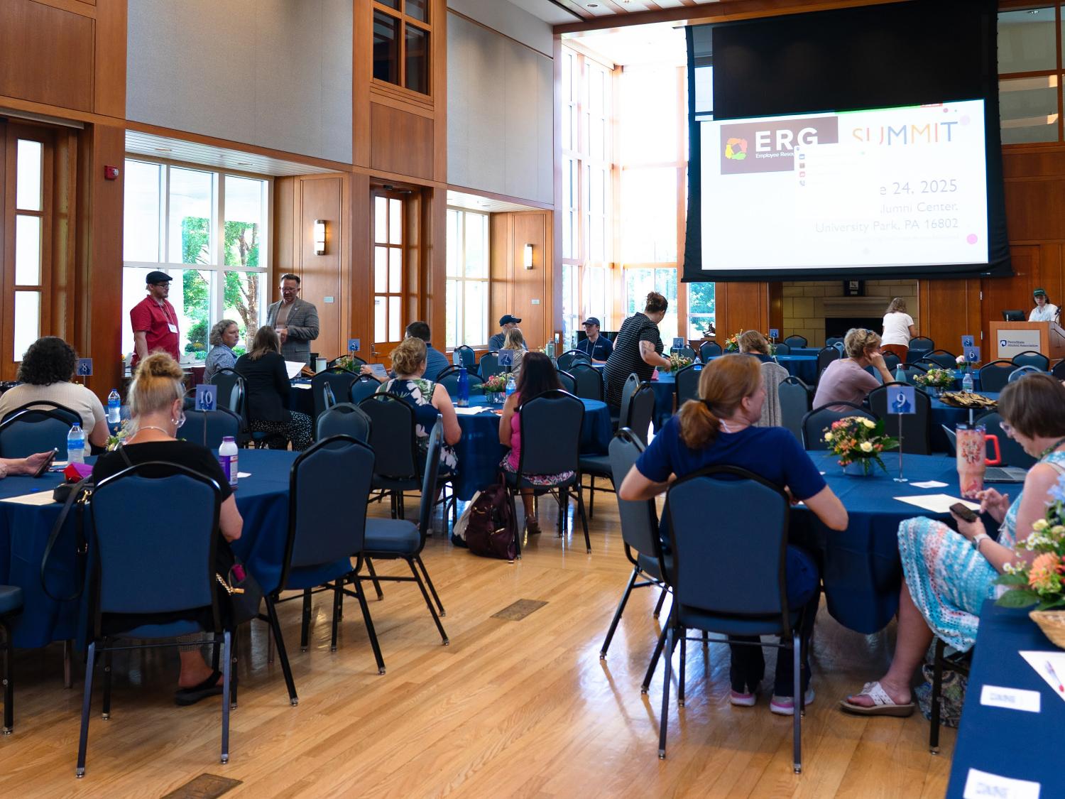 People sitting at tables looking at an overhead projection