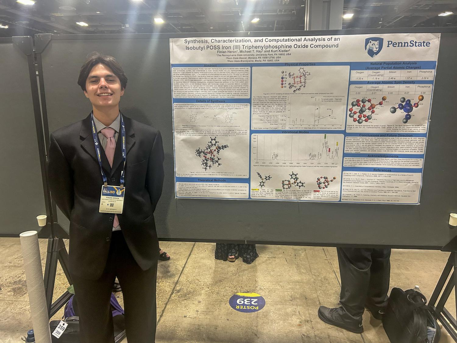 A photo of a student standing next to a poster board presentation