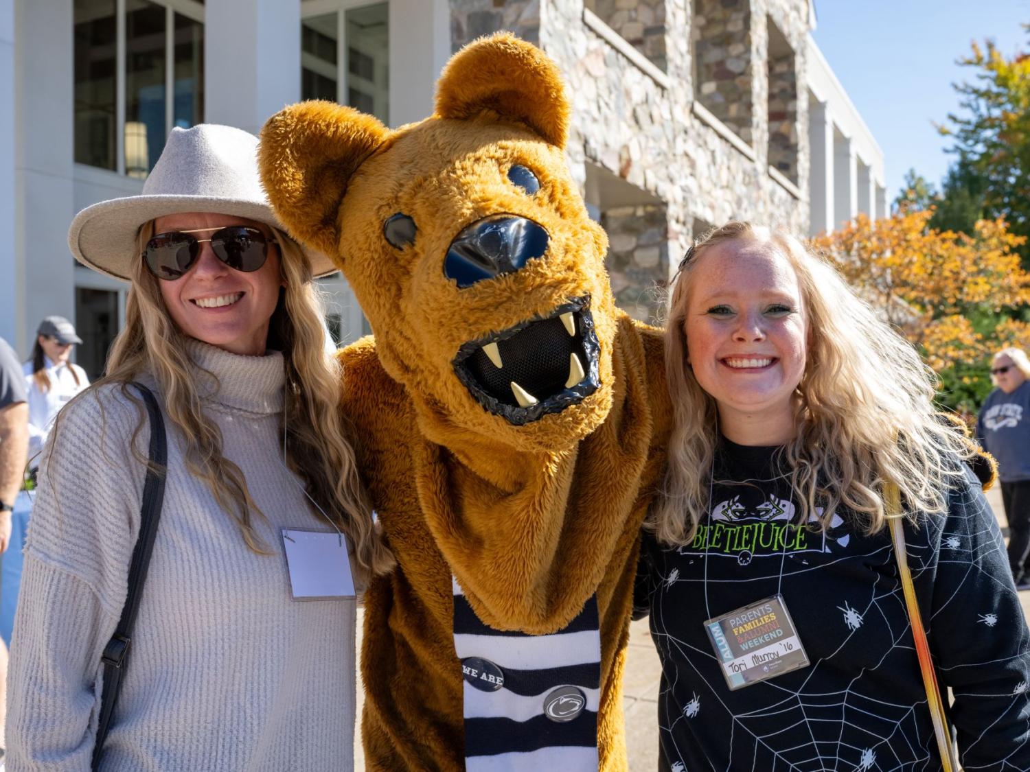 Two women pose with the Nittany Lion at Penn State Behrend's Parents, Families, and Alumni Weekend.