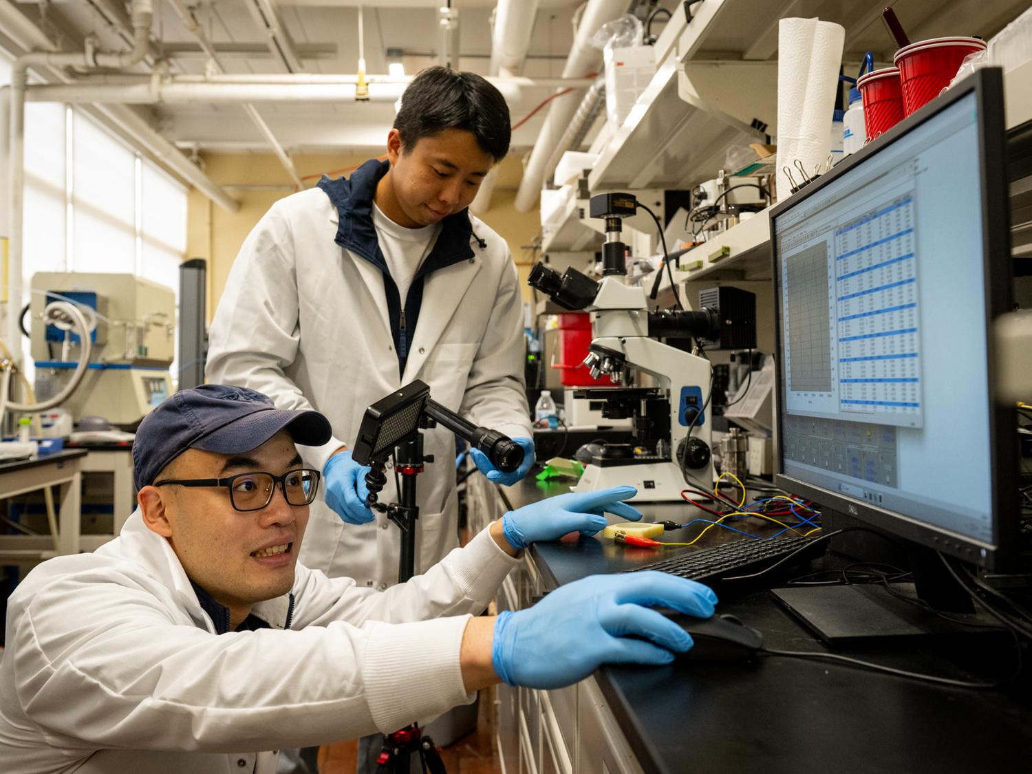 People in a lab, working with different bits of machinery. 