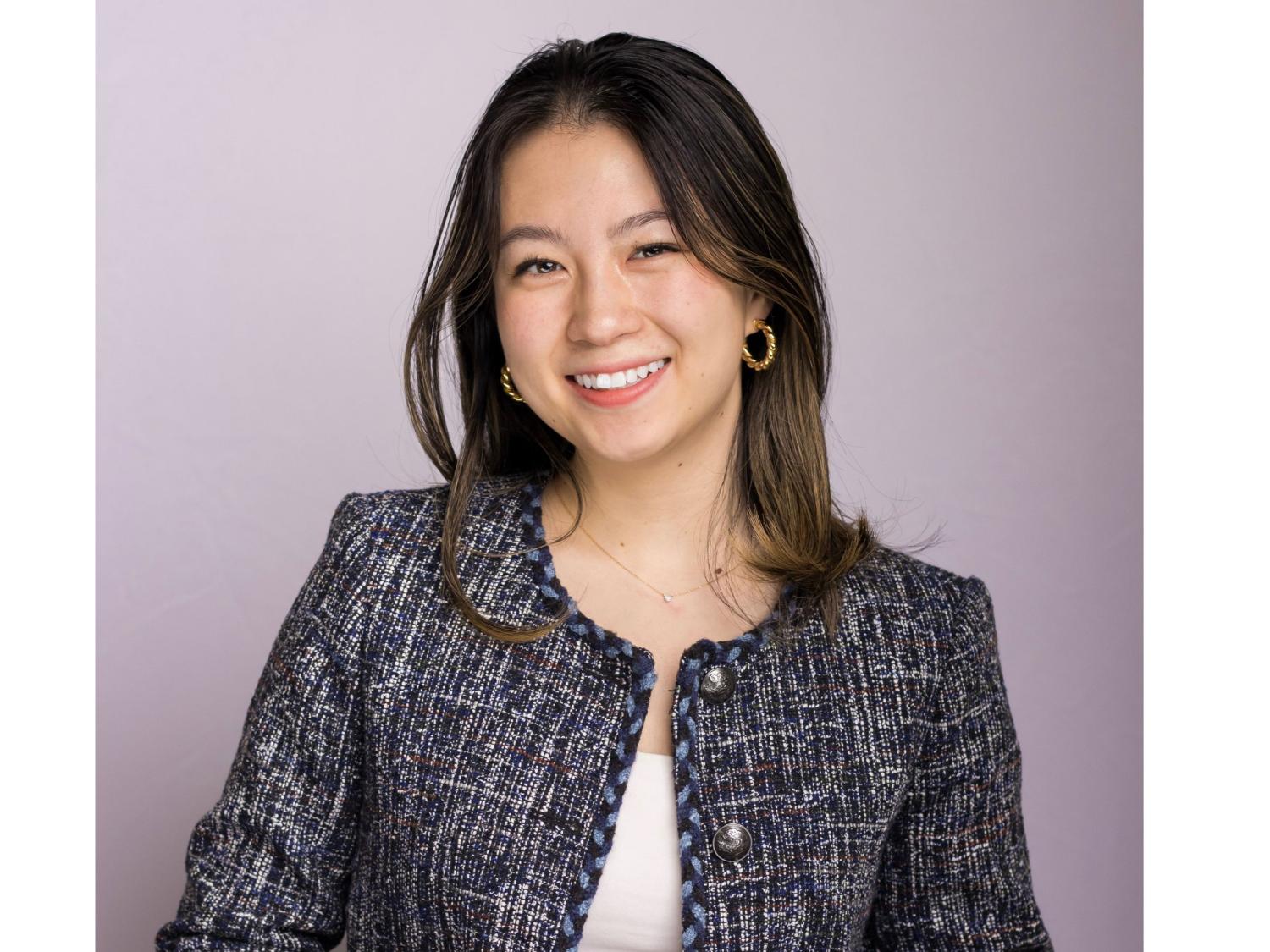 headshot of smiling person with long dark hair, black jacket, white shirt