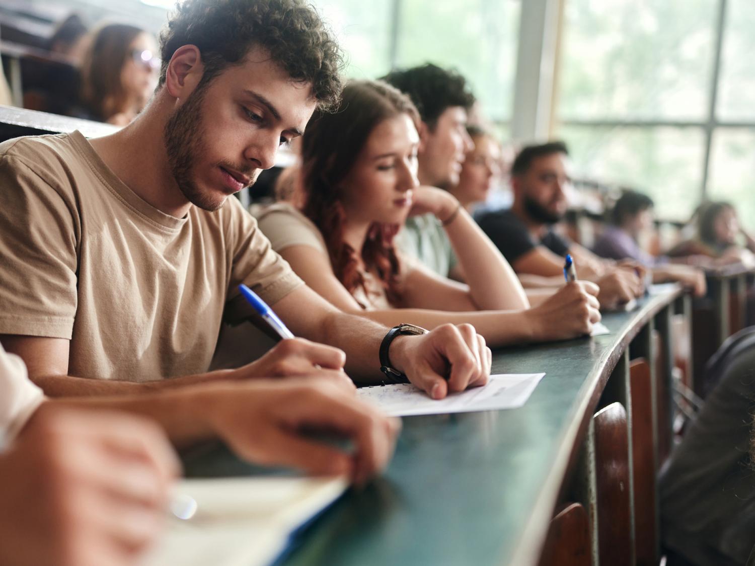 A stock image of students in a classroom writing on papers
