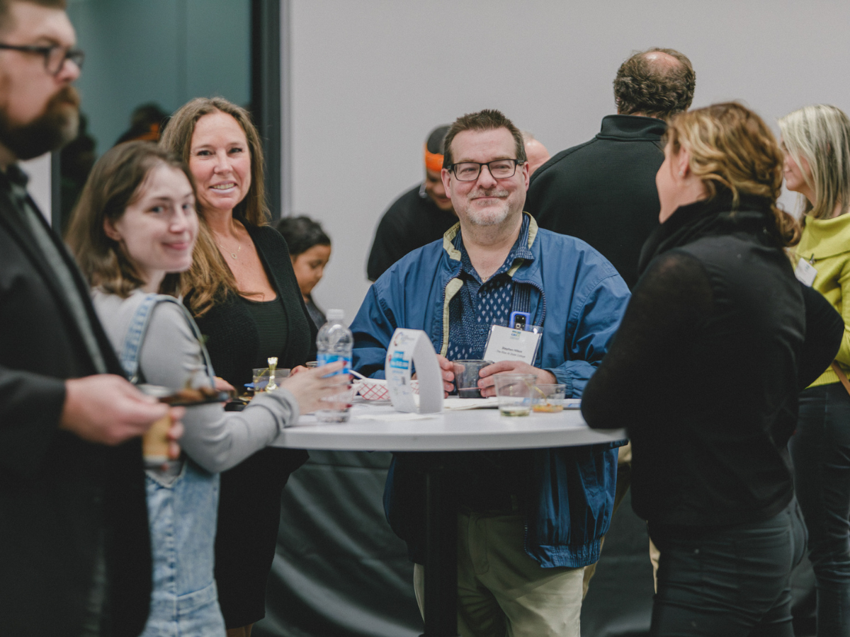 People networking around a standing table