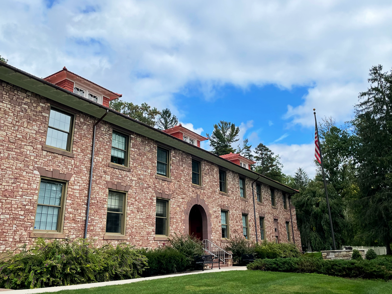 A picture of the American Flag outside Conklin Hall on the campus on Penn State Mont Alto