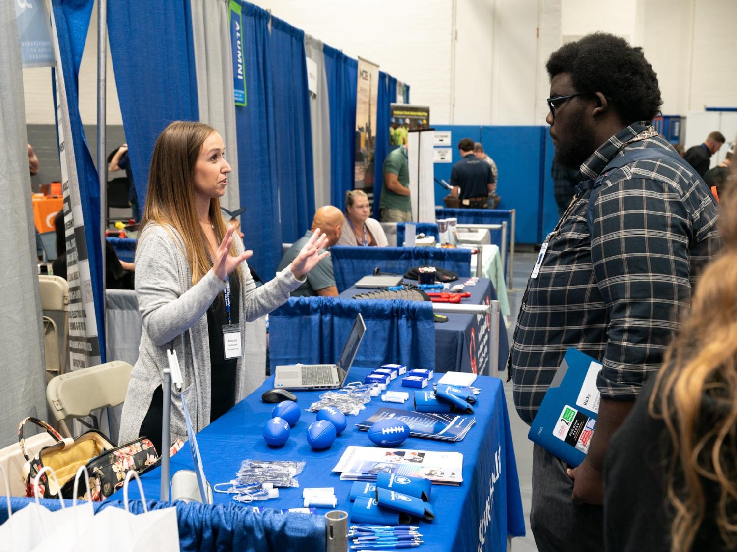 A recruiter and a student talk at a table during the Penn College Fall 2025 Career Fair.