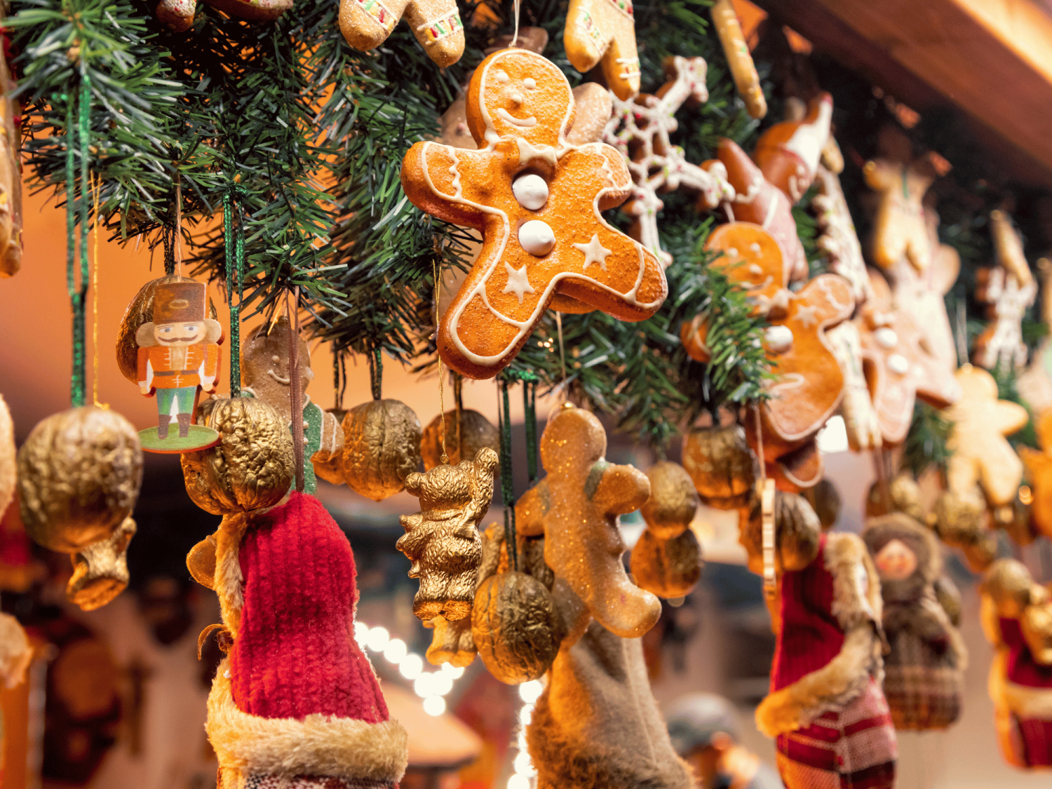 A collection of miscellaneous holiday decor and crafts hanging near greenery 