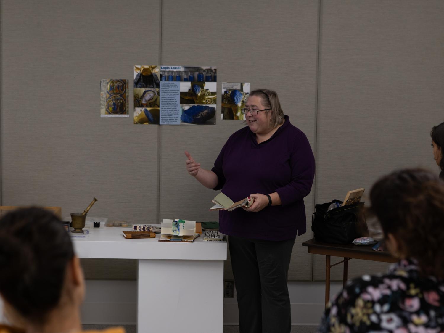 A person dressed in black gives a presentation in front of a class.