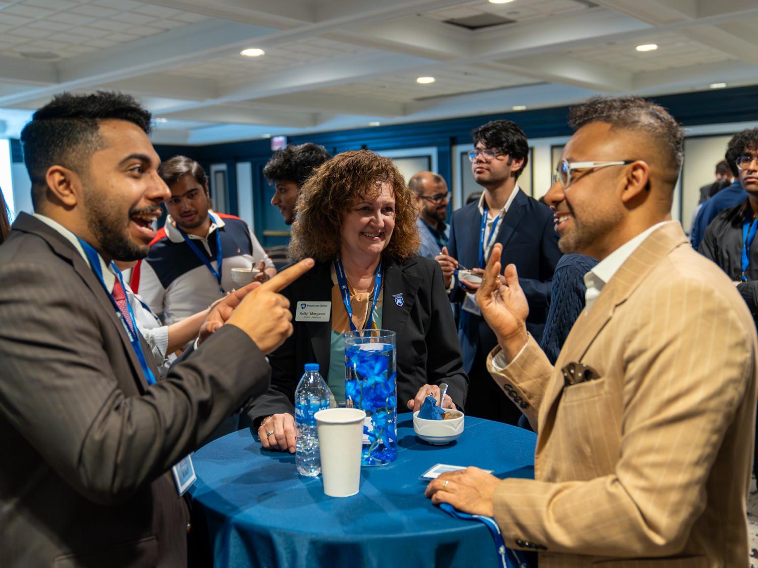 Two men and a woman talking animatedly at a table