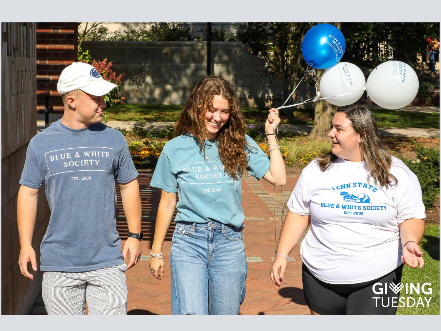 Blue and White Society members walking and wearing t shirt with logos