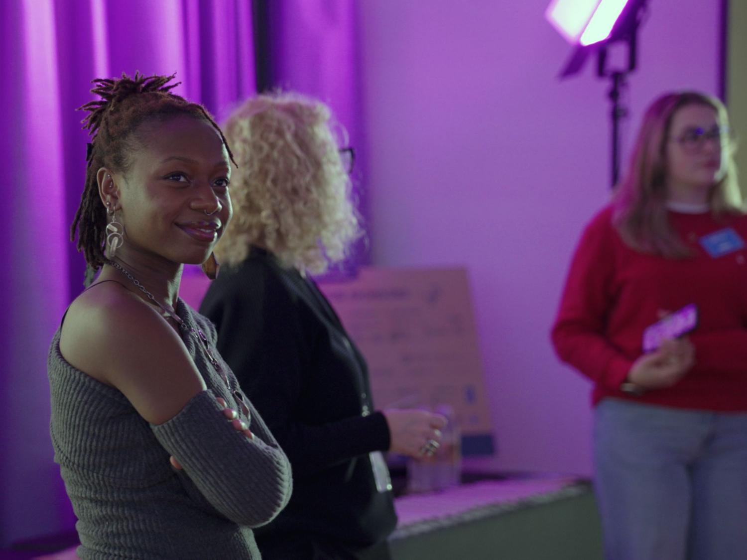 three people in purple room