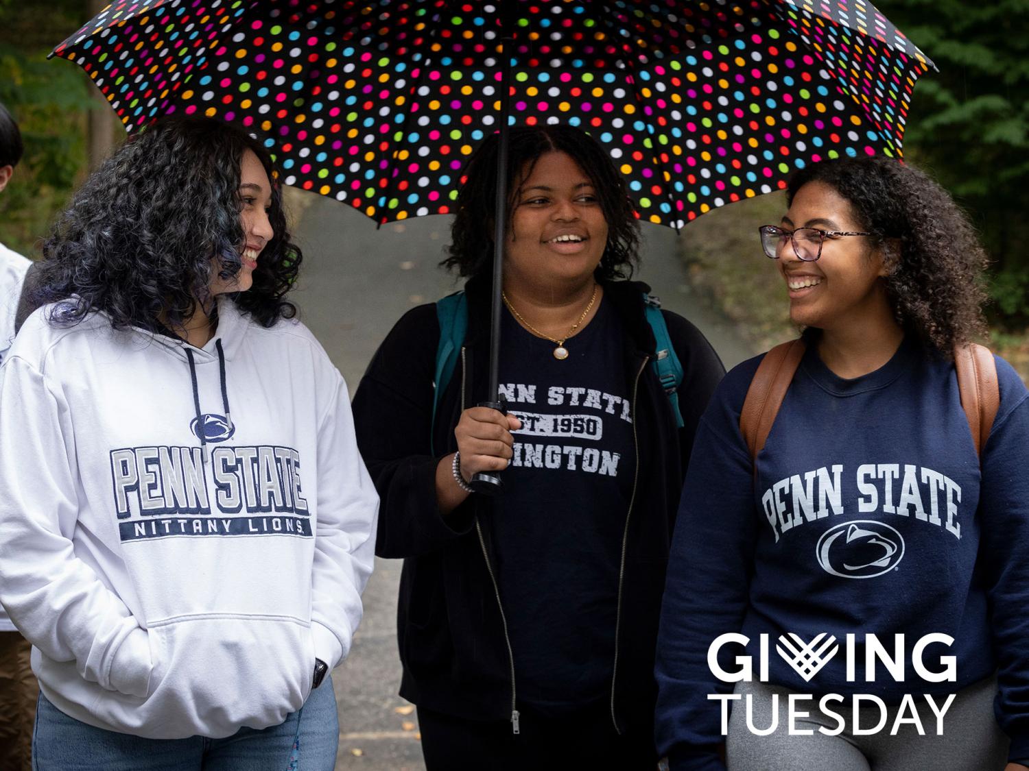 Four people walking under an umbrella