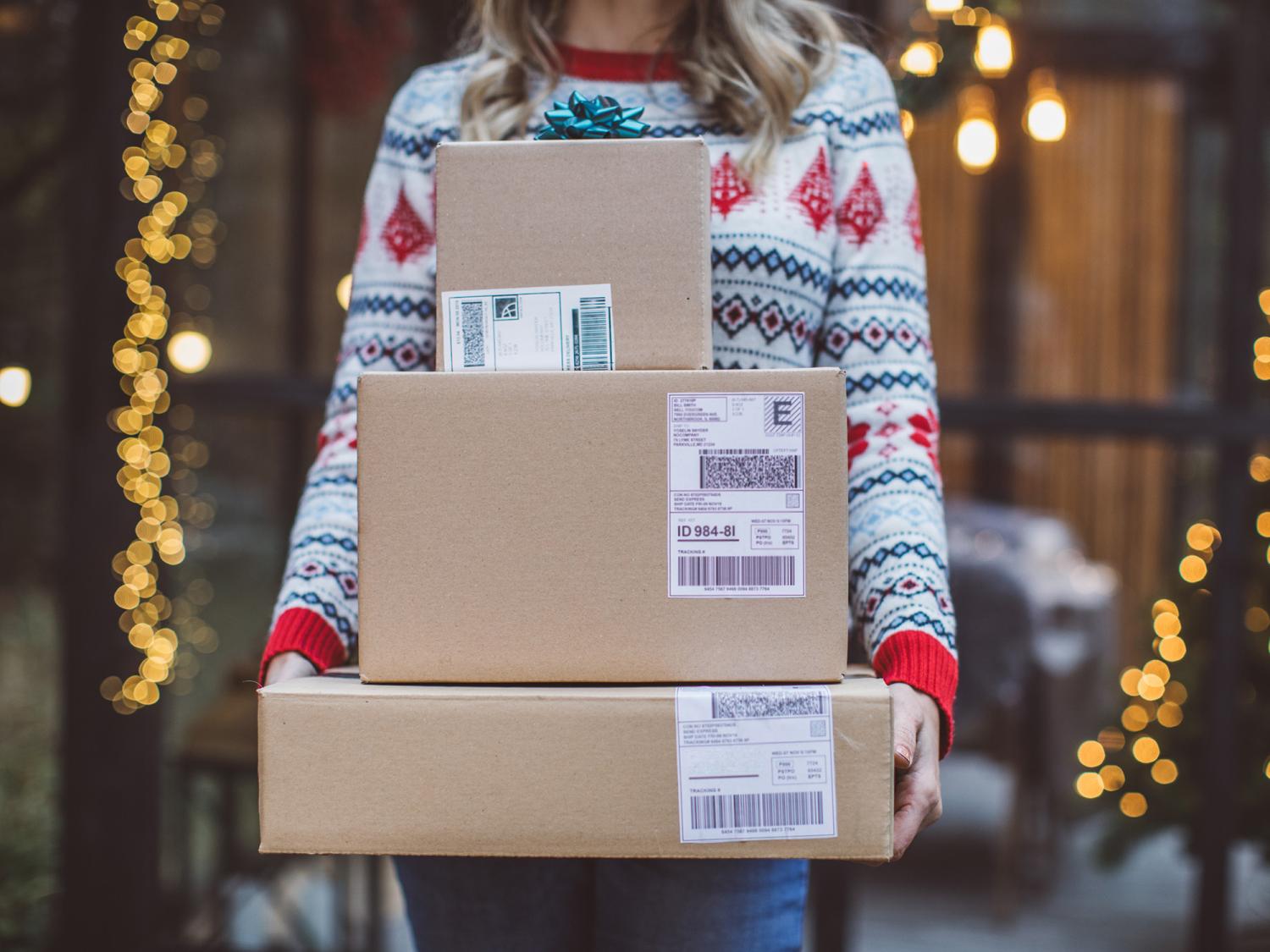 Person in a holiday sweater holding packages