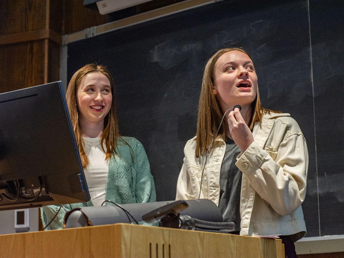 Laura Hendry and Maria Catalano are speaking at a podium.