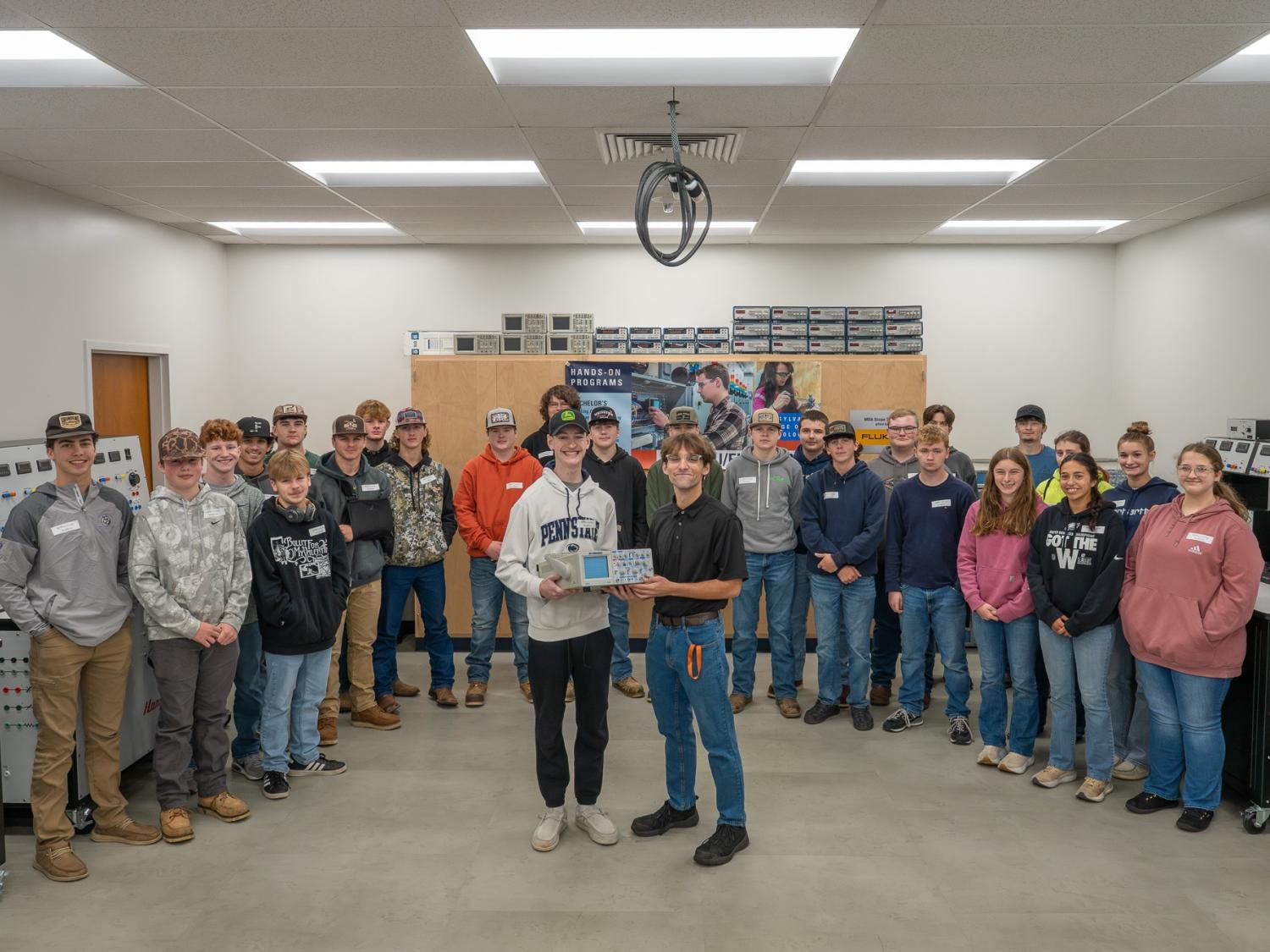 Students from Mifflin County Academy of Science and Technology accept a donation of surplus items from a recently updated Penn College lab after touring the college’s electrical and mechatronics technology space.
