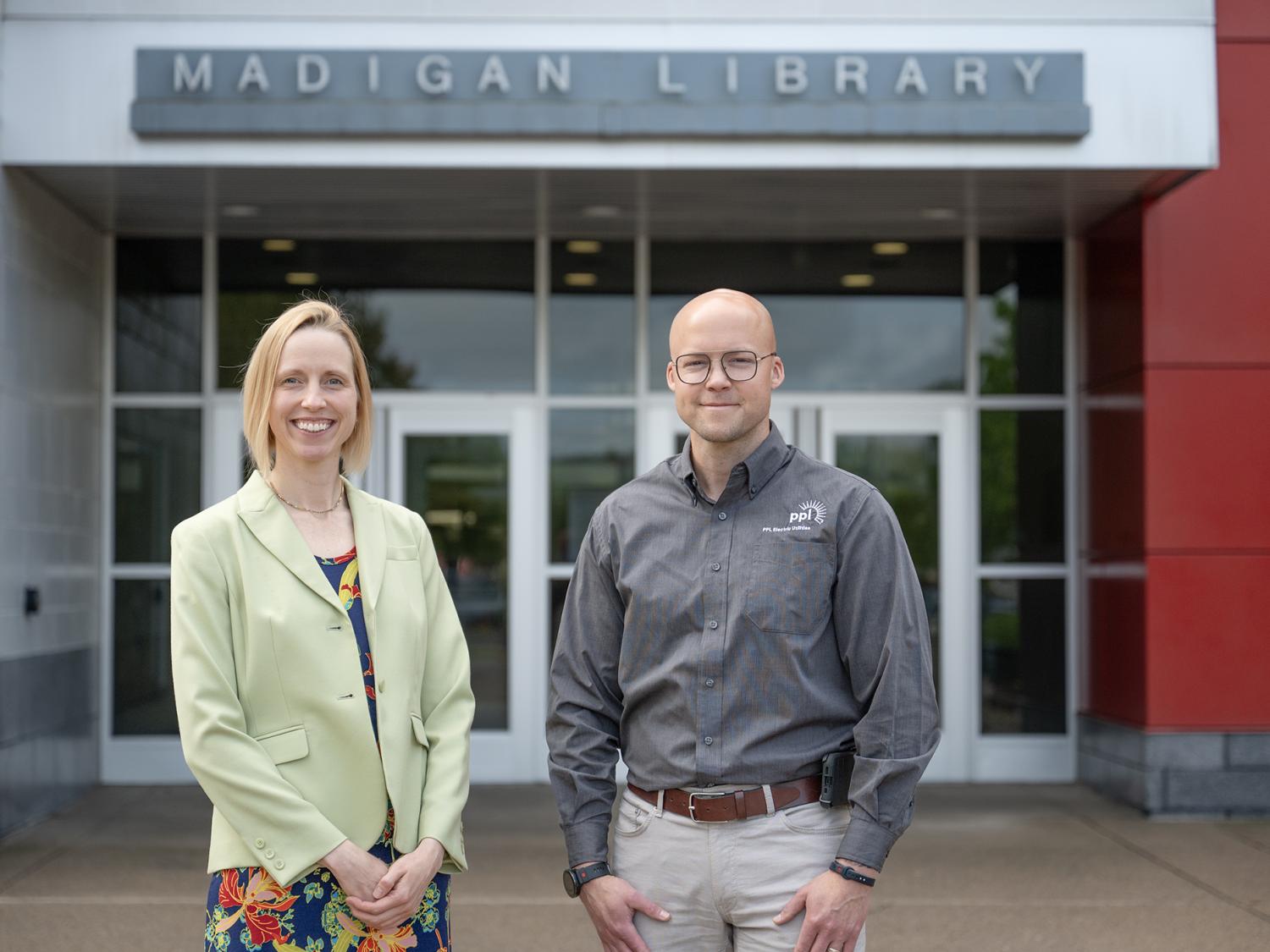 Two people standing in front of a building entrance